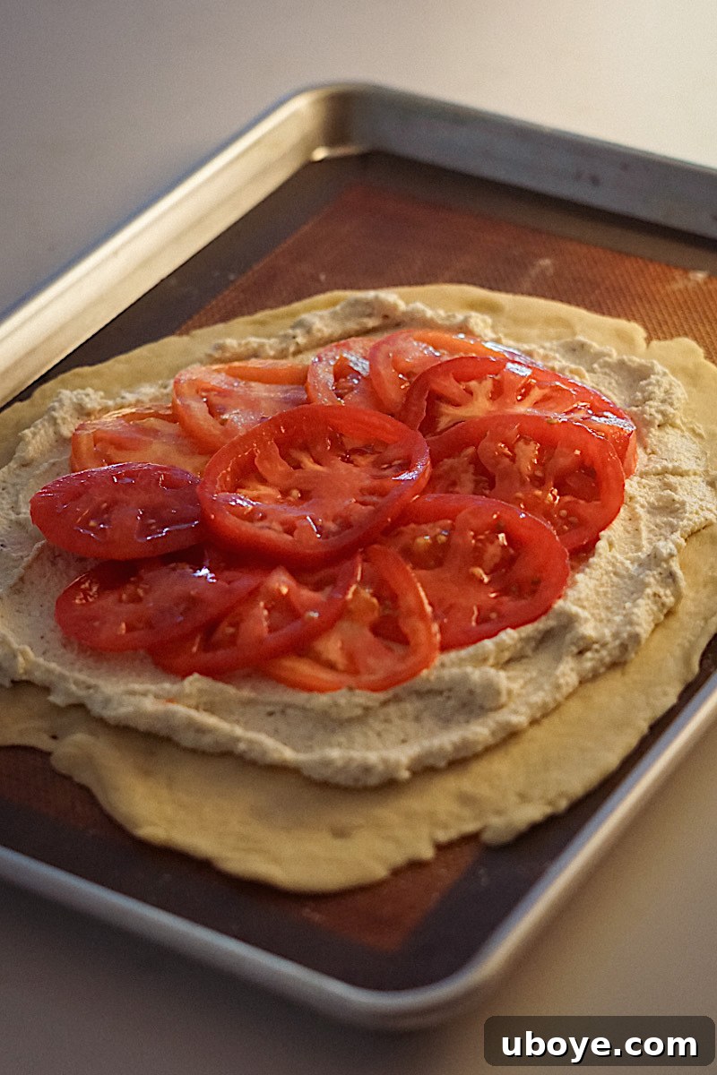 Arranging sliced tomatoes on the galette filling