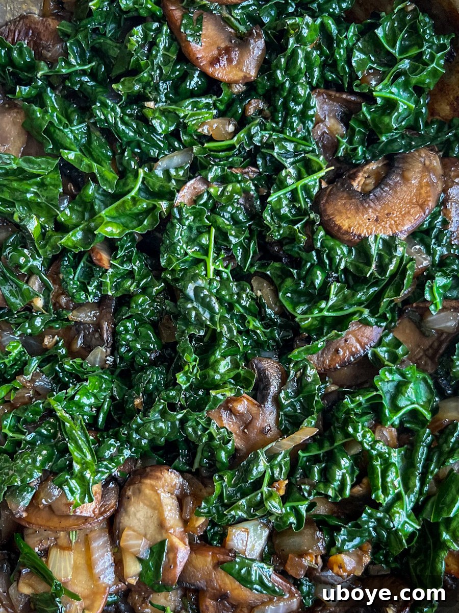 Savory Balsamic Mushroom Tortellini 7 Vegetables including mushrooms, onions, and kale cooking in a skillet.