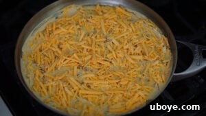 Savory Sweet Potato Skillet 14 Vegan cheddar cheese sprinkled on top of the frittata mixture in a pan
