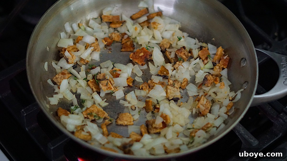 Savory Sweet Potato Skillet 6 Sautéed onions, tempeh bacon, and thyme cooking in a frying pan