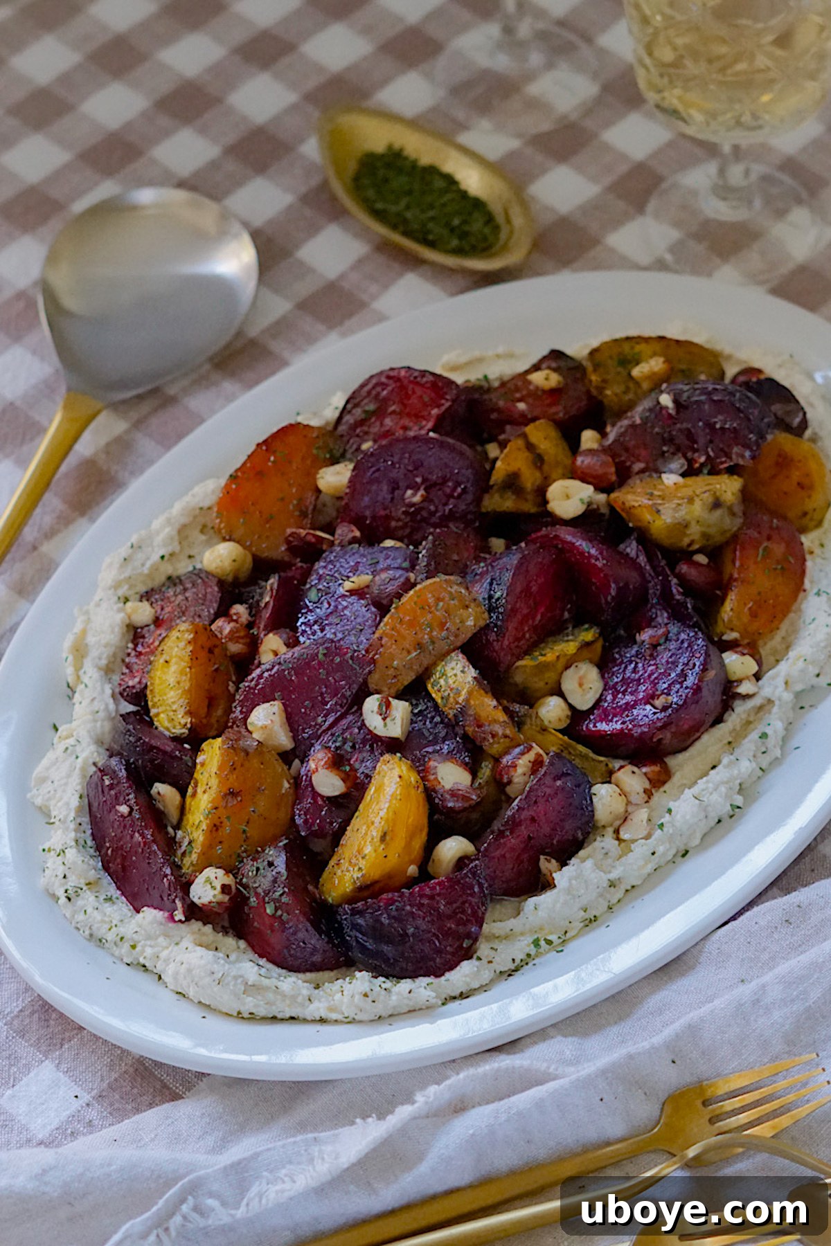 Beautifully plated Roasted Beets with Dairy-Free Whipped Feta, garnished with fresh herbs and toasted hazelnuts