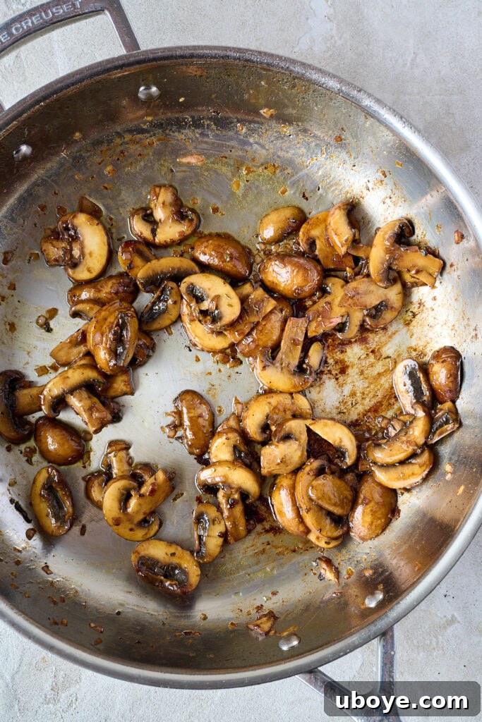 Cooked mushrooms in pan with shallots and butter