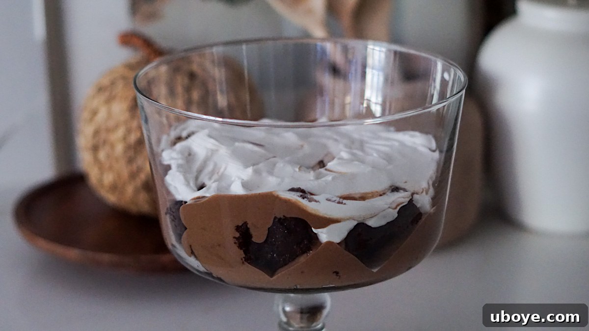 Decadent Chocolate Trifle Made Easy 10 The third layer of whipped cream being spread over the chocolate pudding in the trifle dish.