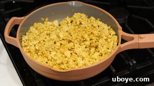 Tofu scramble with spices and cauliflower rice in a skillet