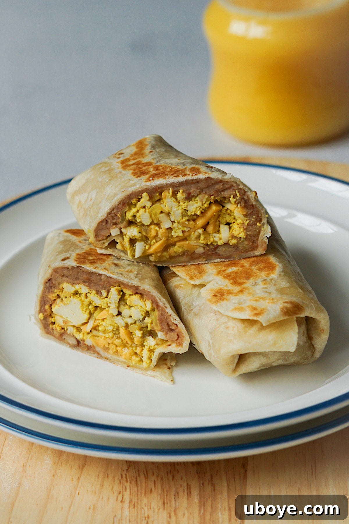 Healthy vegan breakfast burritos arranged neatly on a white plate, showcasing their inviting appearance.