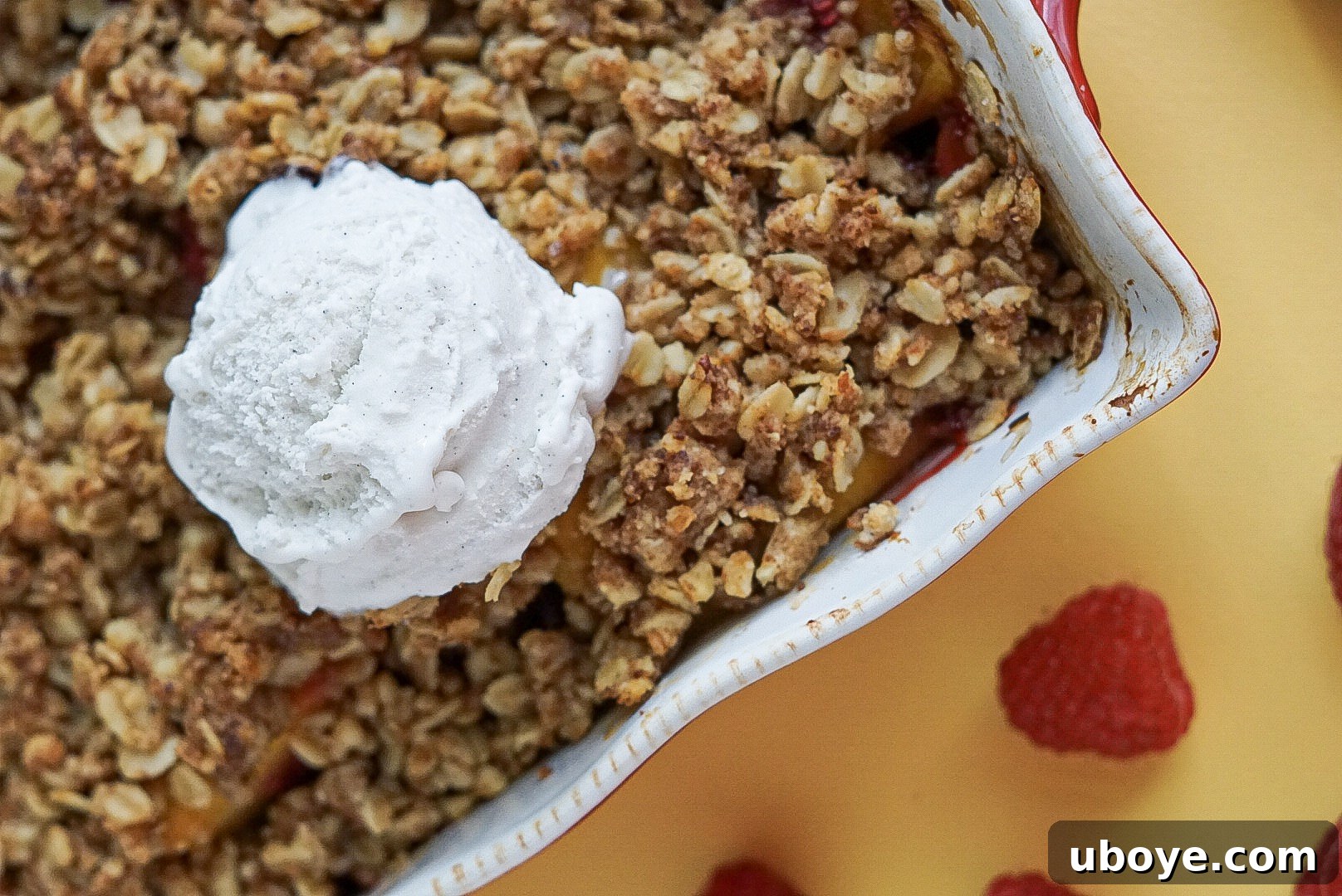 Golden Peach Raspberry Bake 4 Individual serving of vegan peach and raspberry crumble with melted vanilla ice cream