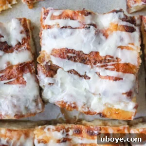 A delicious Cinnamon Scroll Sweet Focaccia, golden brown and drizzled with white glaze.
