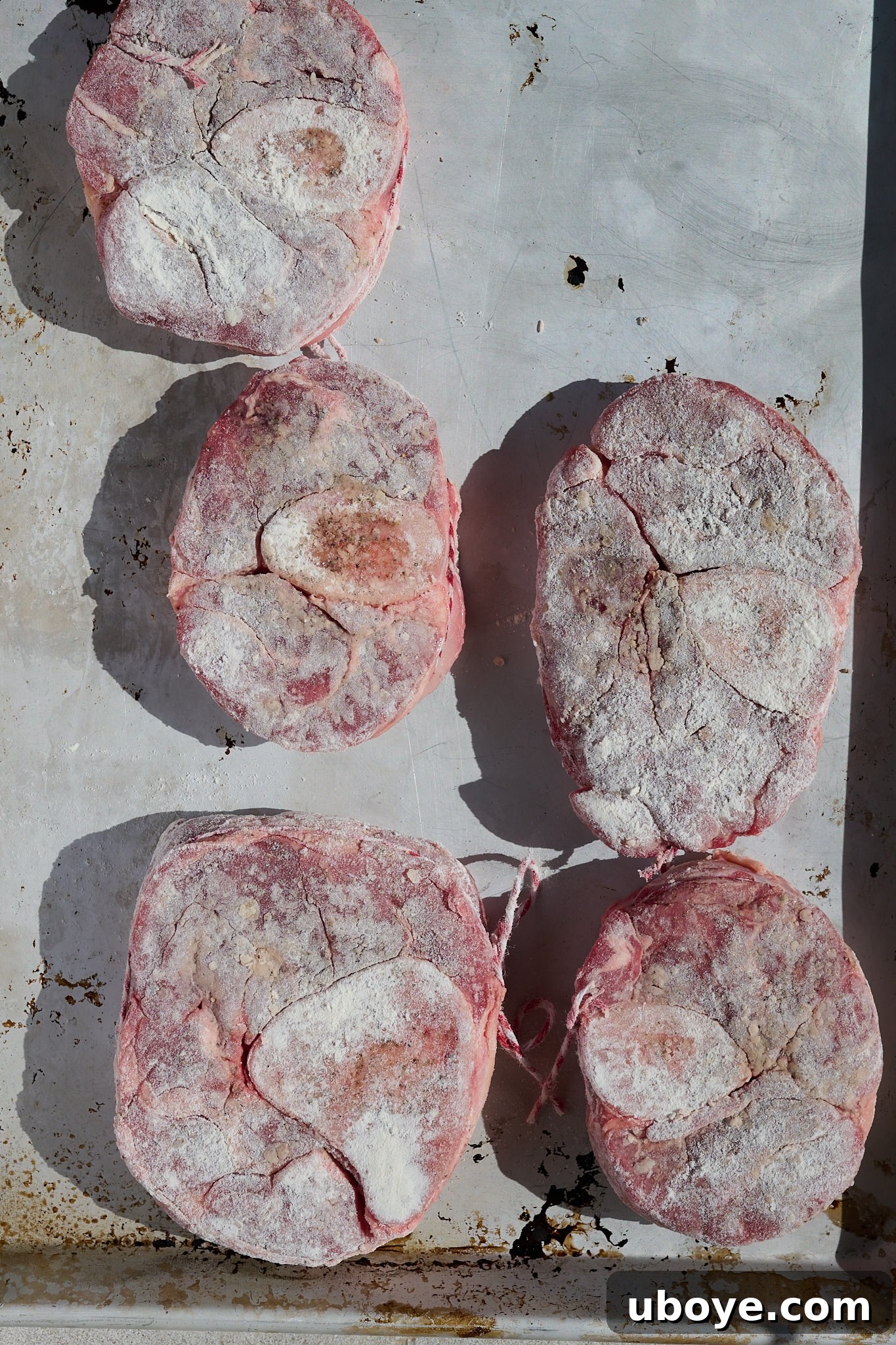 Braised Osso Buco with Zesty Gremolata and Creamy Risotto 5 Veal shanks lightly coated in flour, ready for searing.