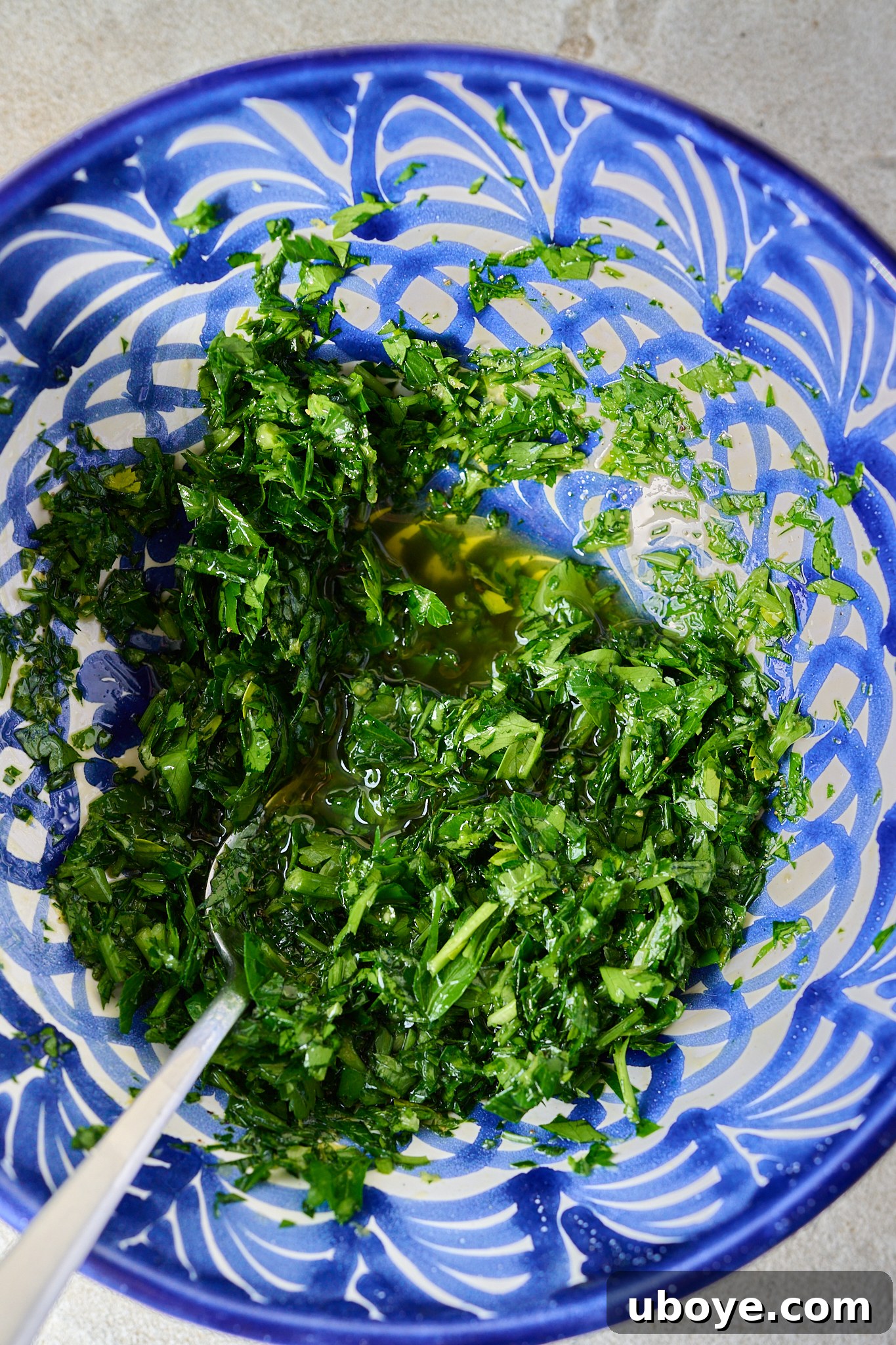 Braised Osso Buco with Zesty Gremolata and Creamy Risotto 10 Fresh ingredients for gremolata in a bowl, including chopped parsley, lemon zest, and garlic.