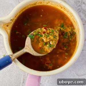 A small white bowl filled with golden Cowboy Butter, garnished with fresh herbs.