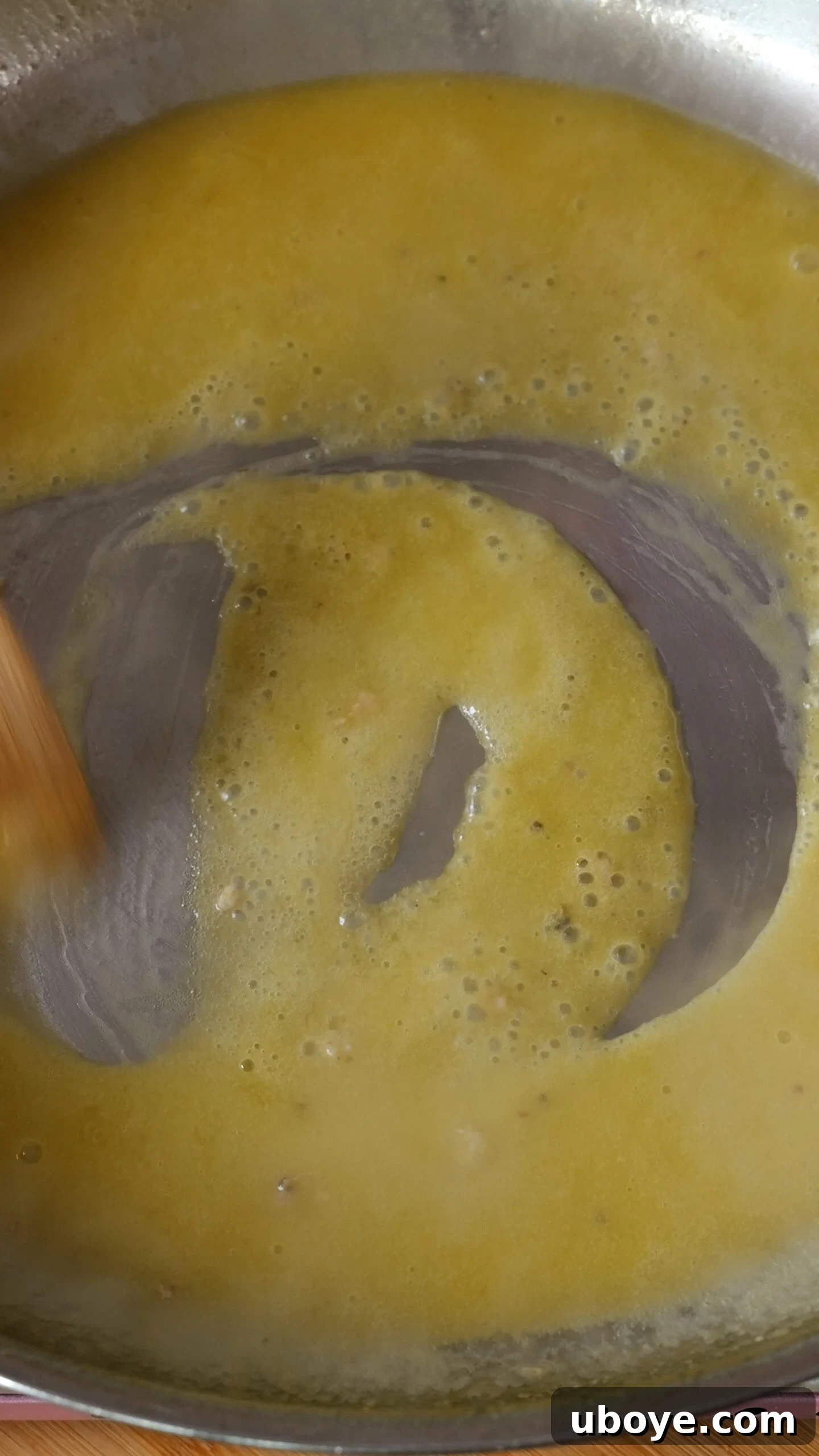 The rich, creamy garlic butter sauce simmering in the stainless steel pan.