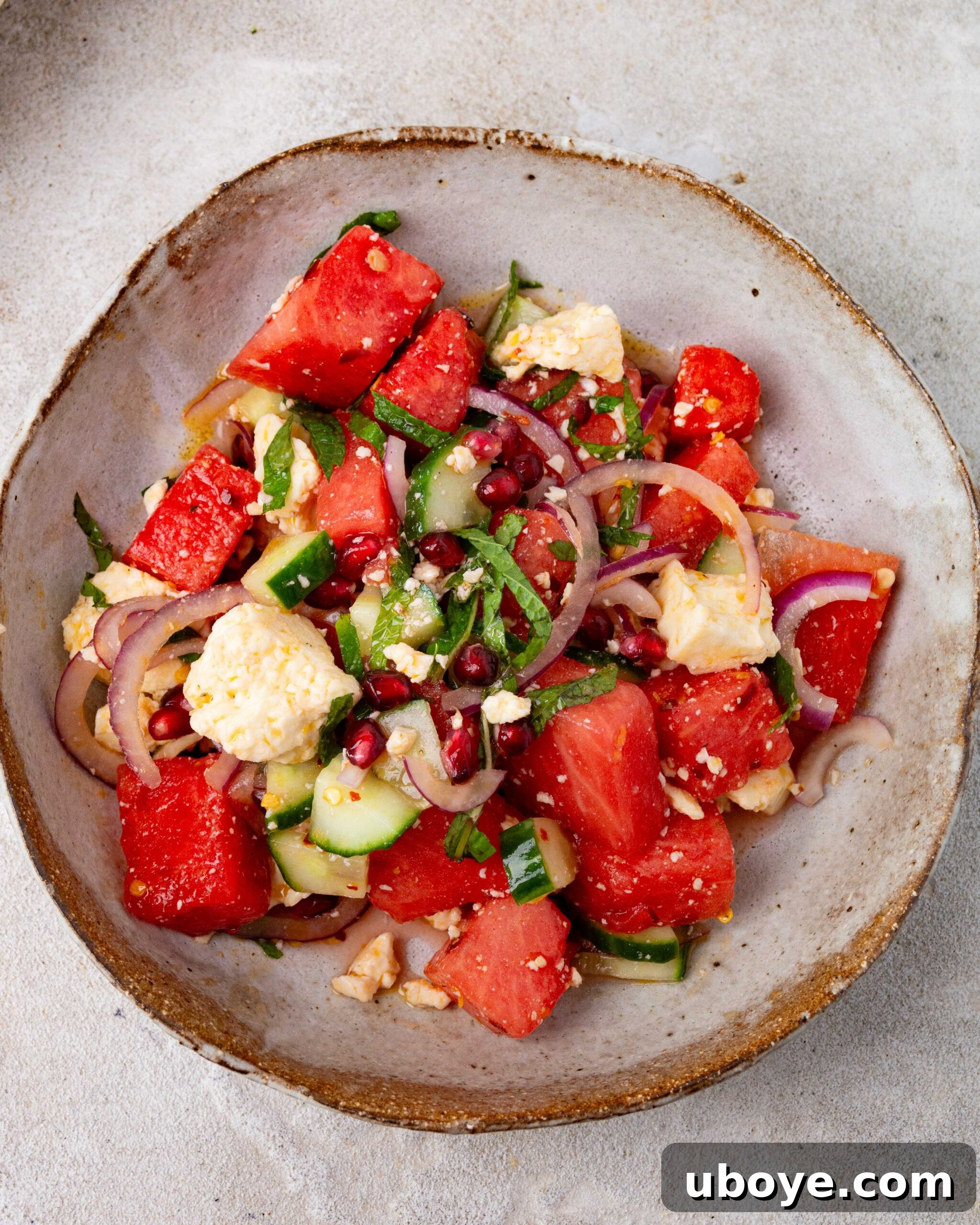 Crisp Watermelon, Feta & Cucumber Medley 3 A smaller brown bowl featuring Feta, Watermelon & Cucumber Salad, garnished with fresh mint, ready to be served.