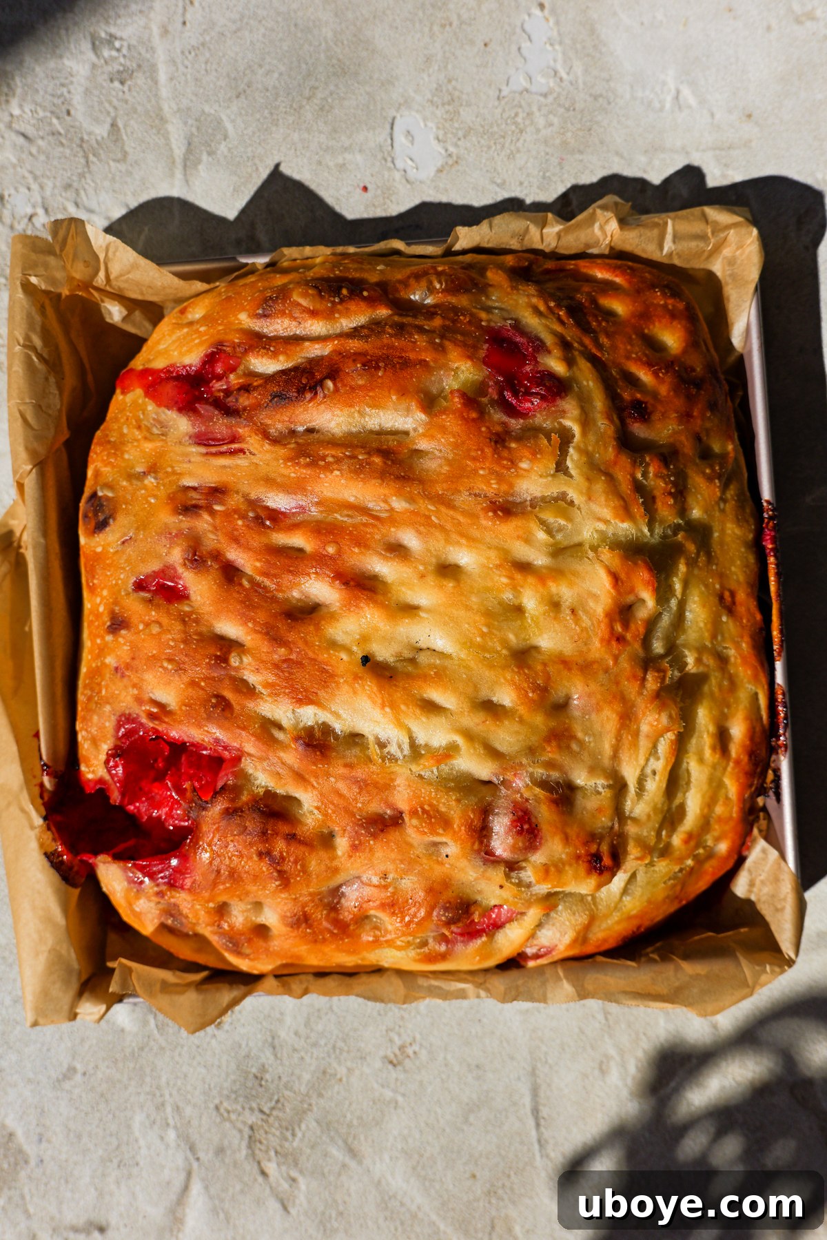 Sweet Focaccia with Strawberry Jam and Cream Cheese Glaze 8 Foccacia dough is baked and sitting in baking tin.