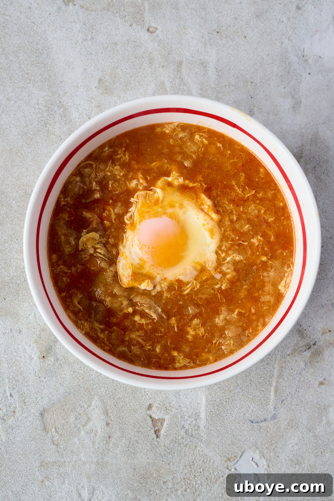 Step 4: A ladle serving hot Sopa de Ajo from a rustic pot into an empty bowl, ready for enjoyment.