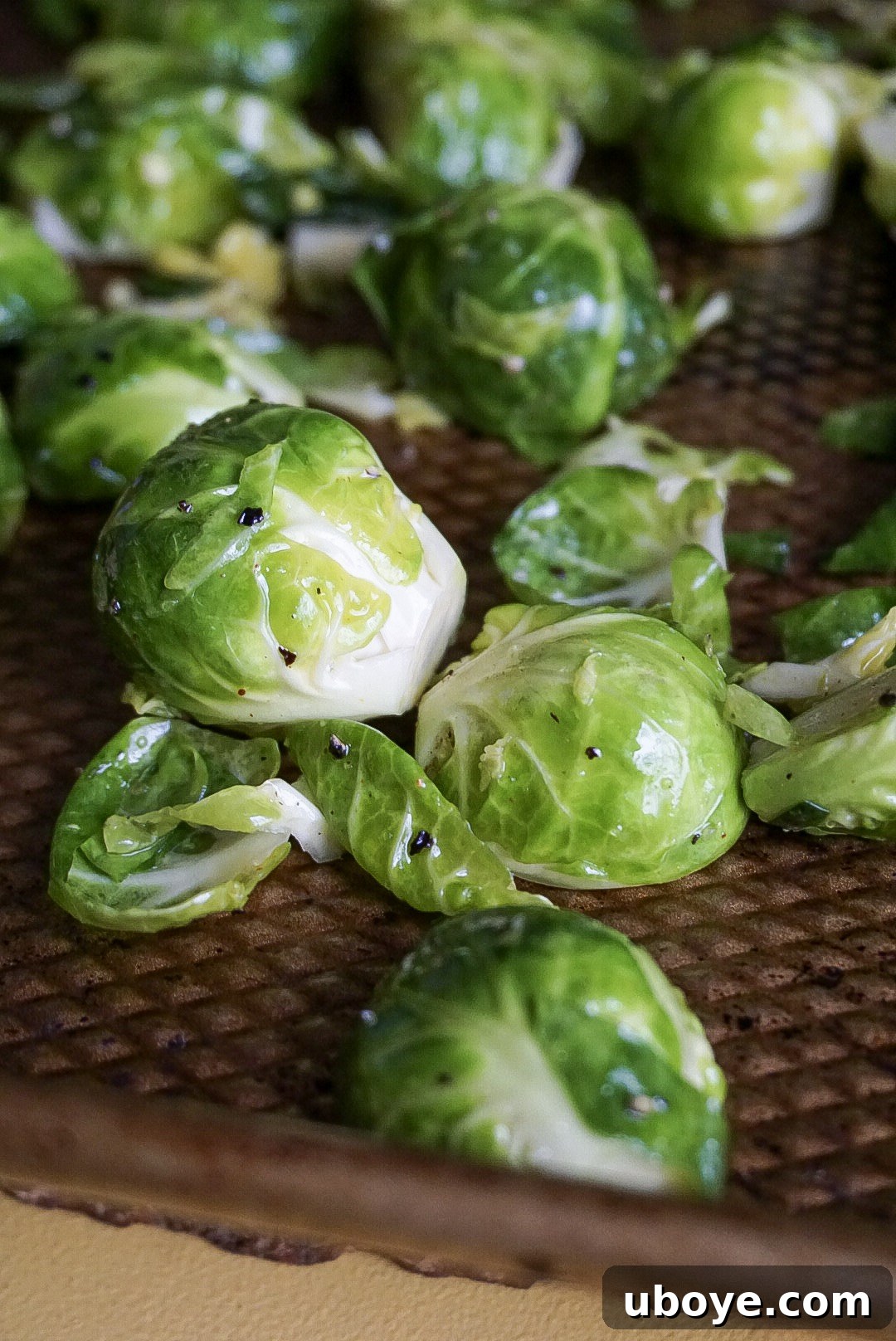 A serving of crispy roasted Brussels sprouts with vegan parmesan, garnished with red pepper flakes.