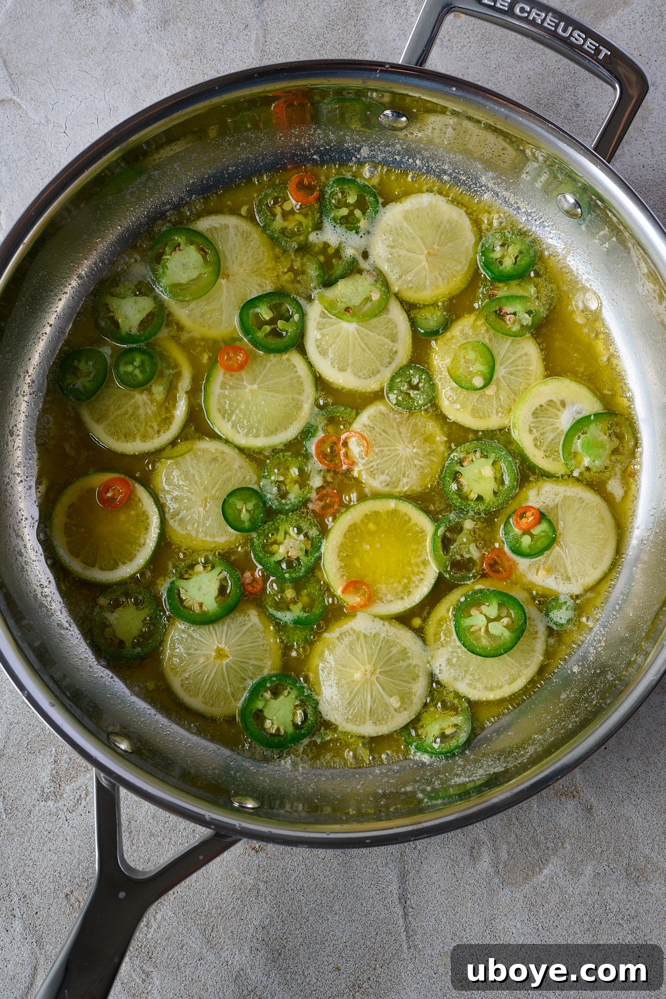 Honey-Chili Slow Roasted Salmon 6 Finely sliced raw limes and jalapeño peppers are submerged in a pool of melted butter within a large stainless steel frypan, heated to begin caramelization.