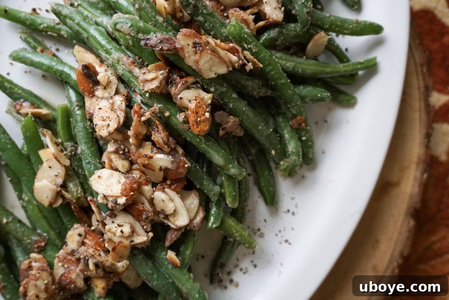 Close-up of the finished brown butter sage green beans with toasted almonds in a serving bowl.