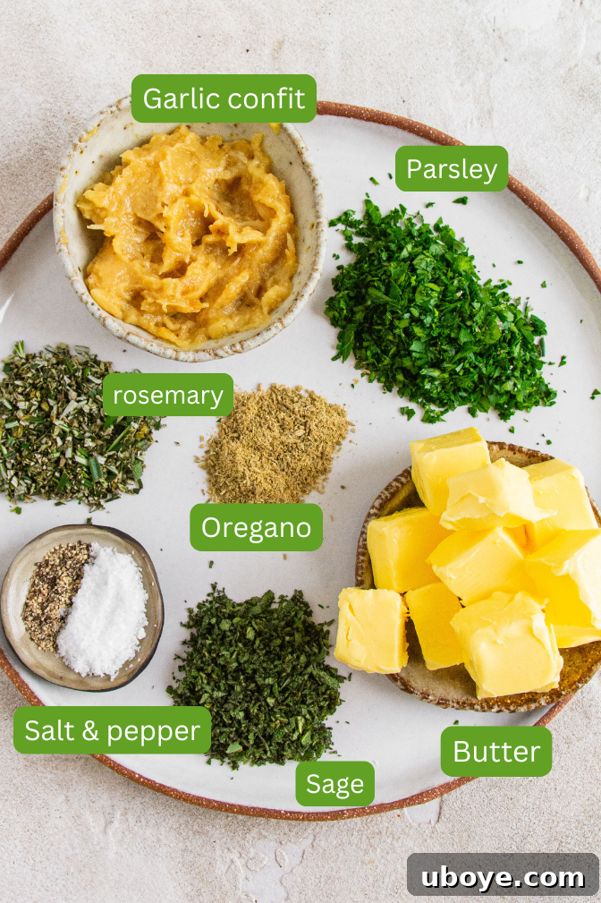 The Ultimate Homemade Garlic Butter 4 Ingredients for homemade garlic butter laid out on a white plate: garlic confit, parsley, rosemary, oregano, butter, salt and pepper, sage.