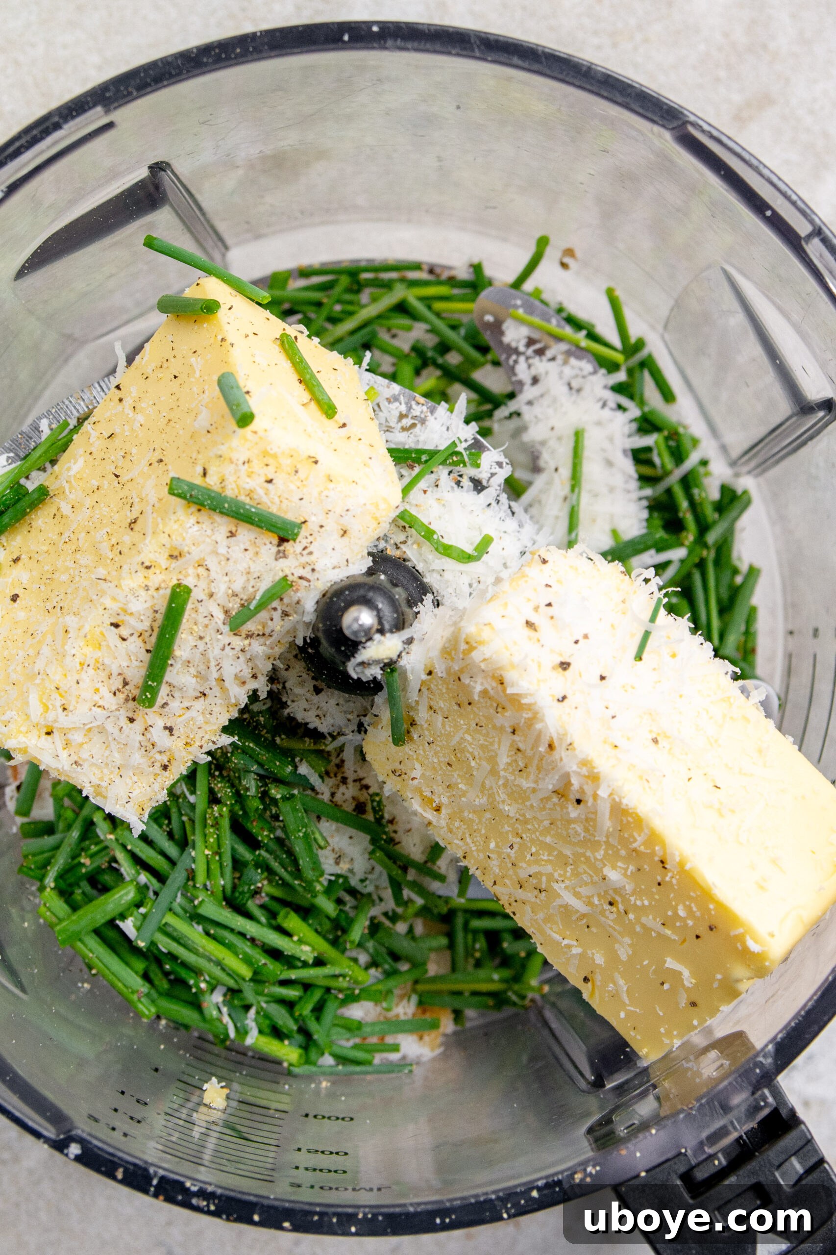 The Ultimate Homemade Garlic Butter 6 Softened butter, fresh herbs, and roasted garlic cloves have been added to a blender, ready to be combined into garlic butter.