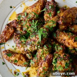 Oven-baked crispy chicken wings coated in a vibrant lemon garlic sauce.