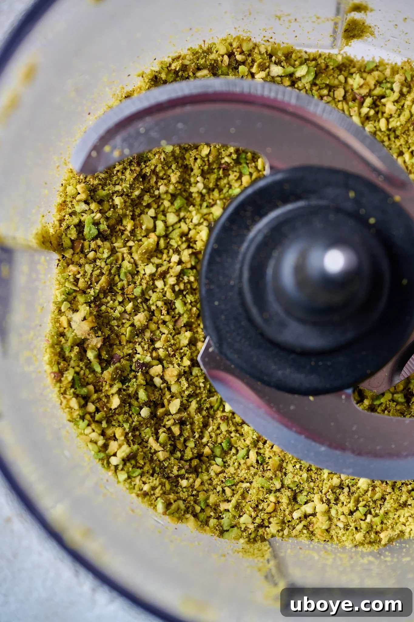 Velvet Olive Oil Cake with Pistachio, Raspberry and White Chocolate 5 Finely ground pistachios ready for baking, showcasing their vibrant green color and fine texture.