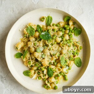 Spring Pea Pasta 4 A beautifully plated bowl of Pasta e Piselli, garnished with fresh mint and a sprinkle of grated cheese, ready to be enjoyed.