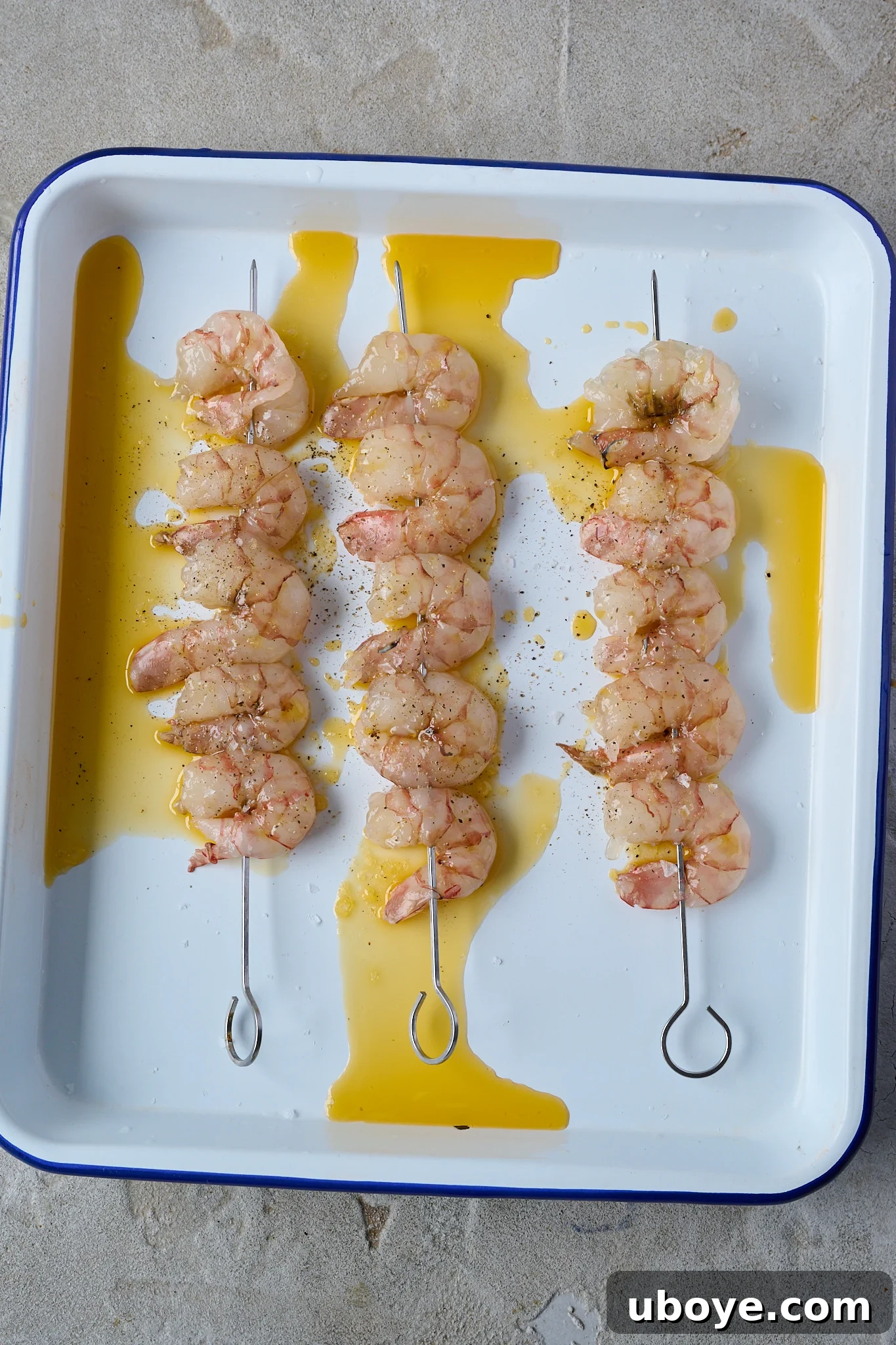 Smoky Grilled Shrimp Skewers with Zesty Tomato Butter 7 Prawns on platter have olive oil drizzled all over
