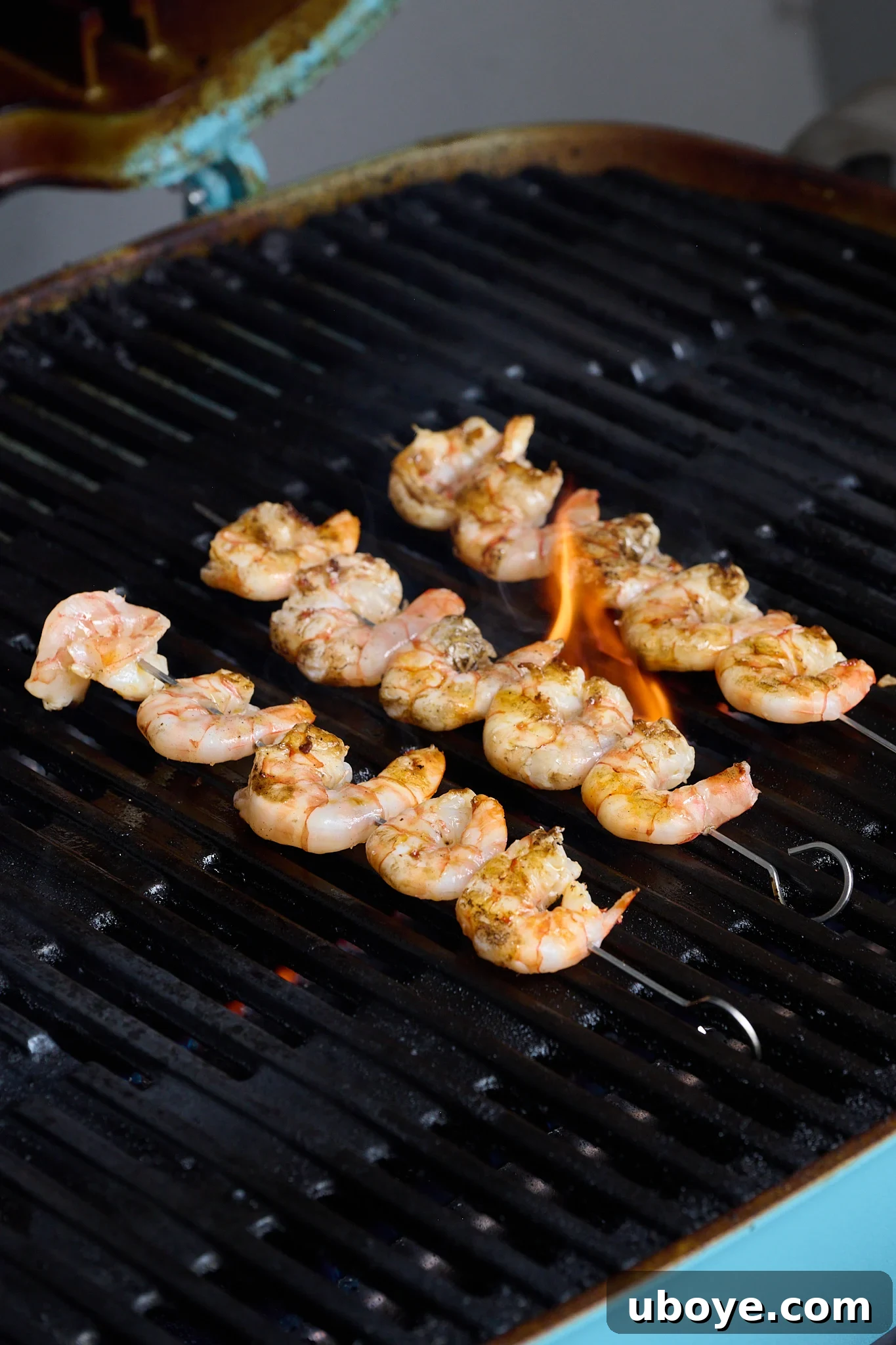 Smoky Grilled Shrimp Skewers with Zesty Tomato Butter 8 Shrimp are shown on BBQ.