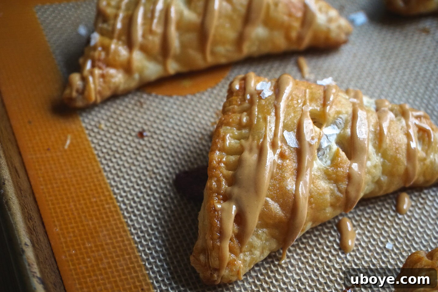 Simple Flaky PBJ Hand Pies 10 Two hands holding a freshly baked vegan peanut butter and jelly turnover