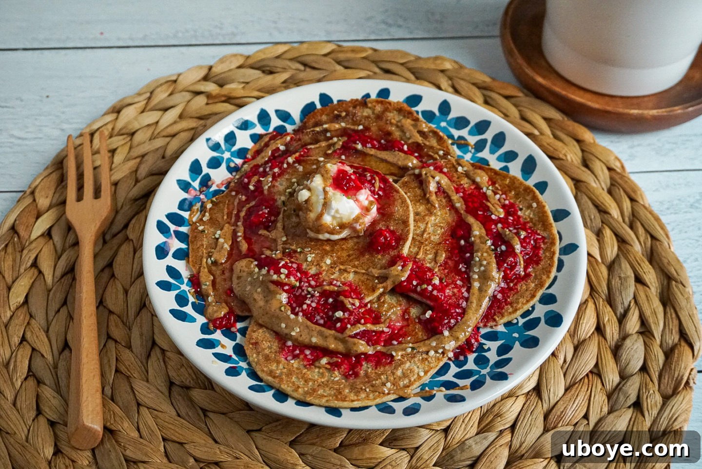 Fluffy 4-Ingredient Pancakes 5 A stack of golden brown vegan banana oat pancakes with fresh berries and maple syrup.