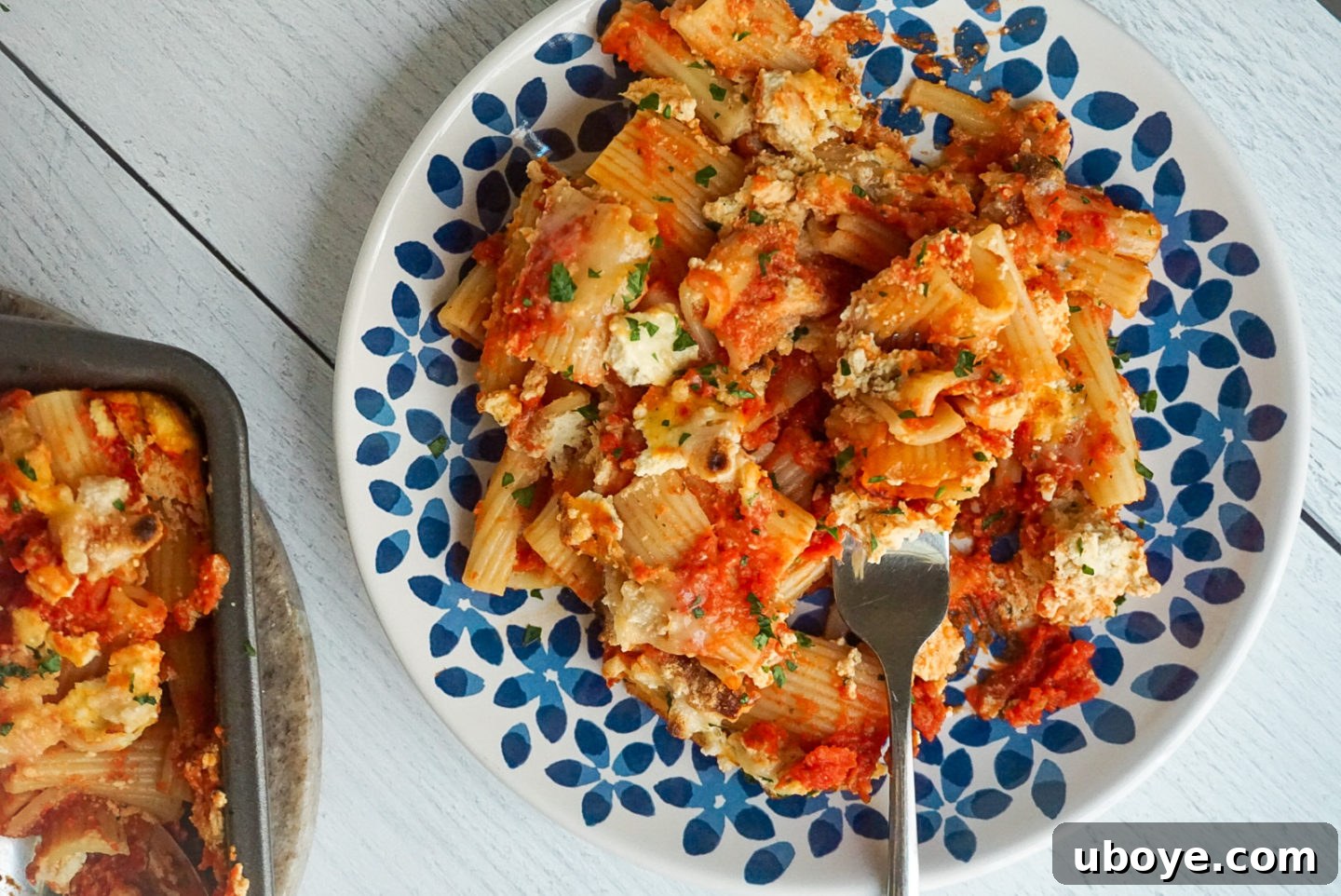 Close-up shot of vegan baked ziti layers before baking, showing tofu ricotta and sauce.