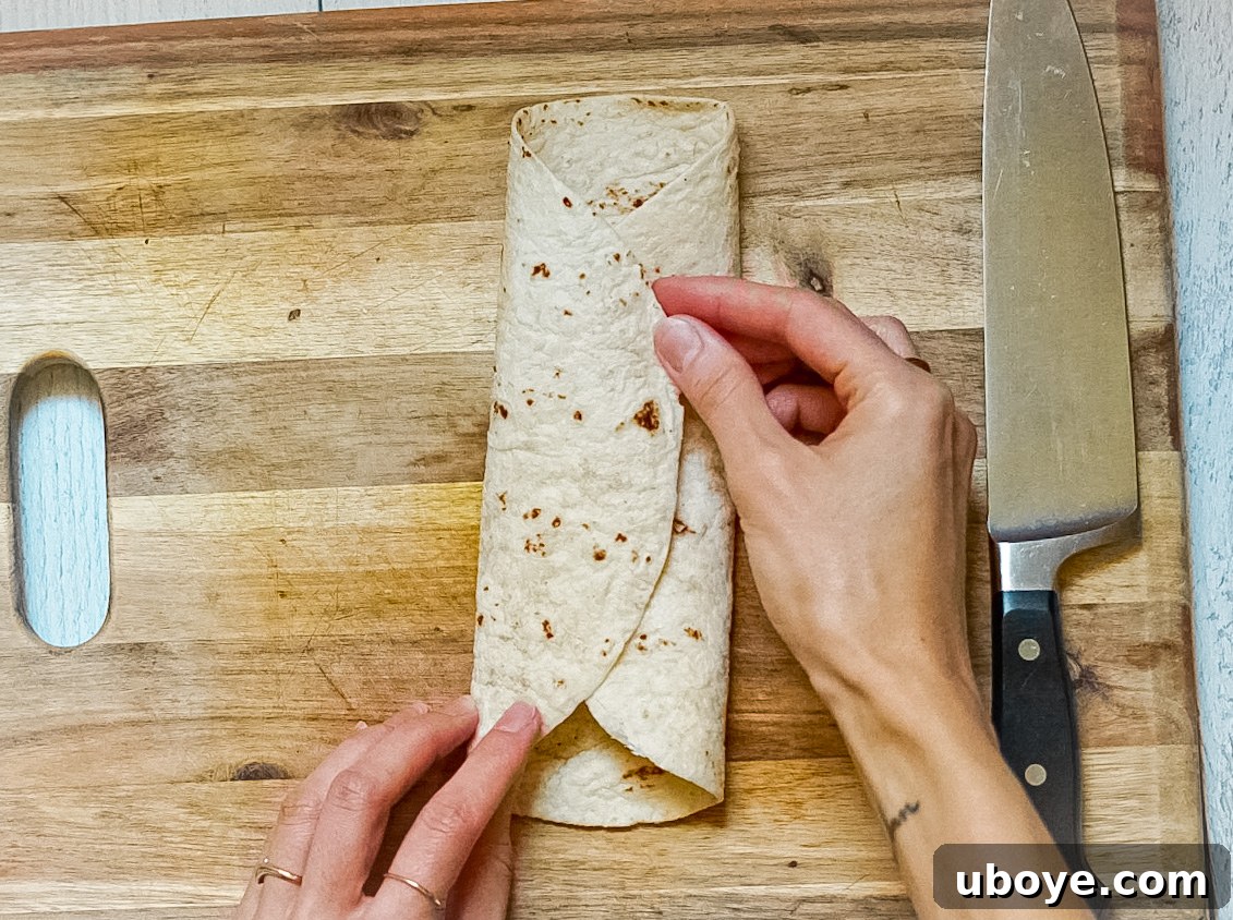 Plant-Powered Toaster Quesadillas 10 Image showing the third fold, with both left and right thirds of the tortilla folded towards the center.