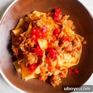Close-up of Ragu Bolognese simmering in a pot, showcasing its rich texture and color.
