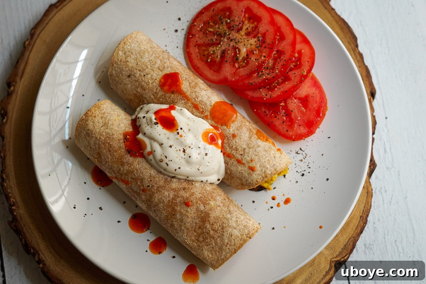 Golden Bacon Cheddar Breakfast Bites 8 Plated vegan breakfast taquitos with hot sauce