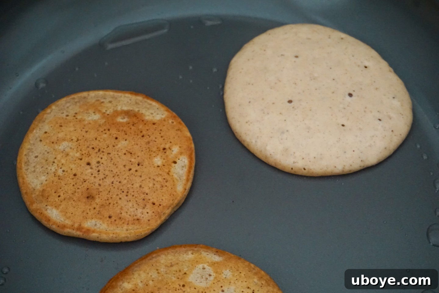 A close-up shot of a stack of fluffy vegan mango pancakes, showcasing their golden-brown exterior and soft texture.