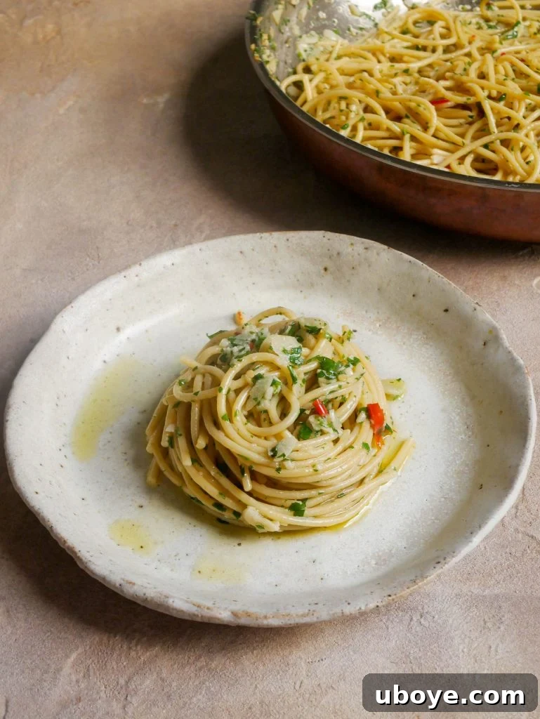 Classic Garlic and Olive Oil 3 A close-up view of Aglio e Olio pasta being tossed in a pan, highlighting the glossy texture of the sauce.