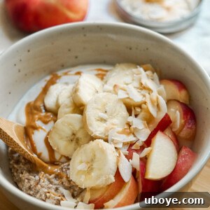 Overnight oats in a glass jar topped with fresh fruit and almond butter