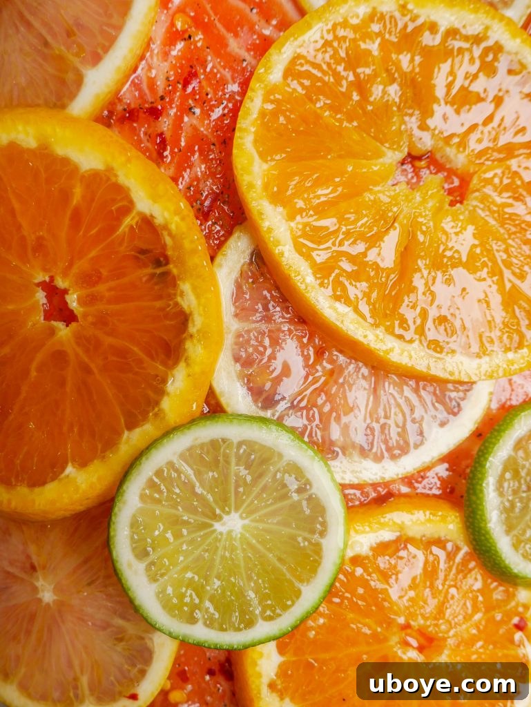 Close-up of roasted salmon on a baking sheet, garnished with fresh herbs and citrus.