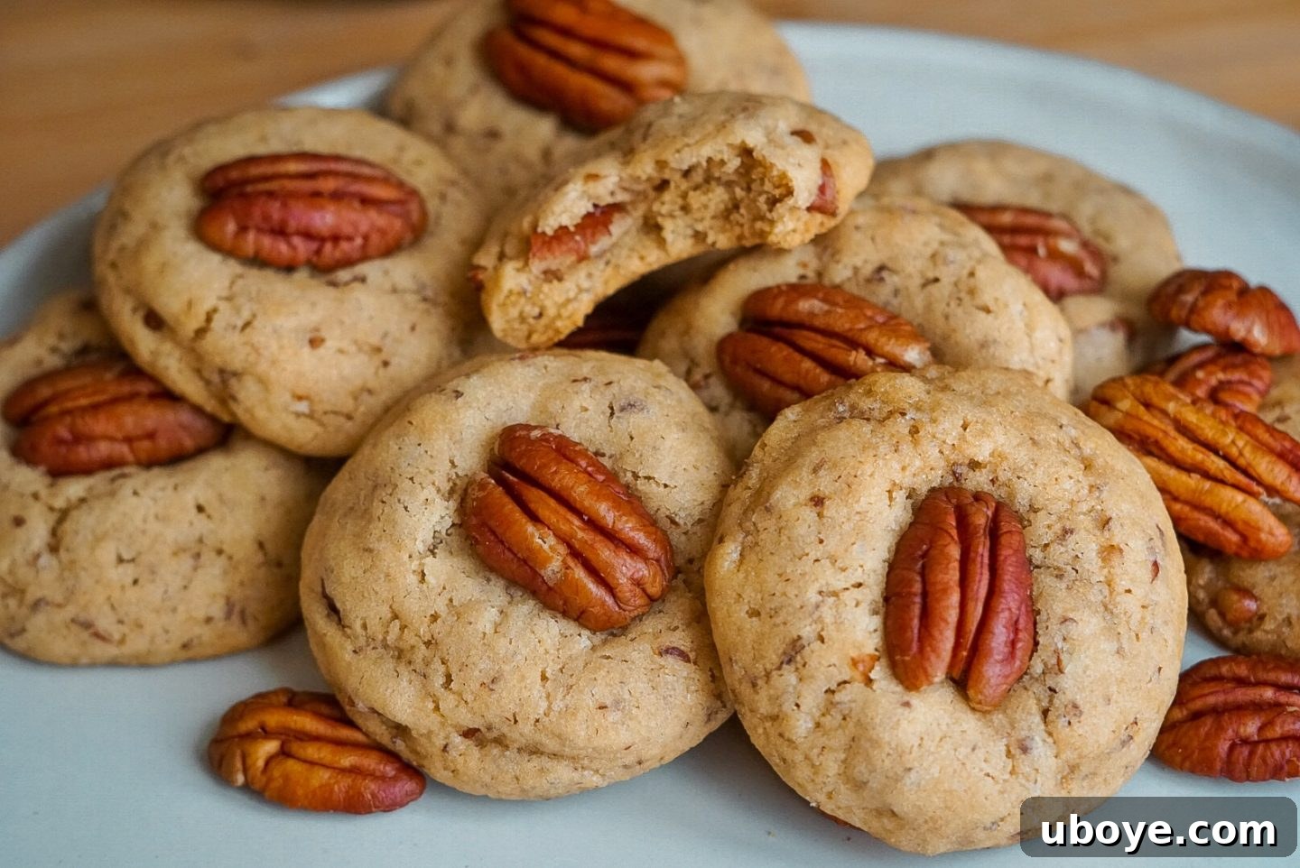 A perfectly baked vegan butter pecan cookie on a cooling rack, showcasing its golden-brown edges and soft center