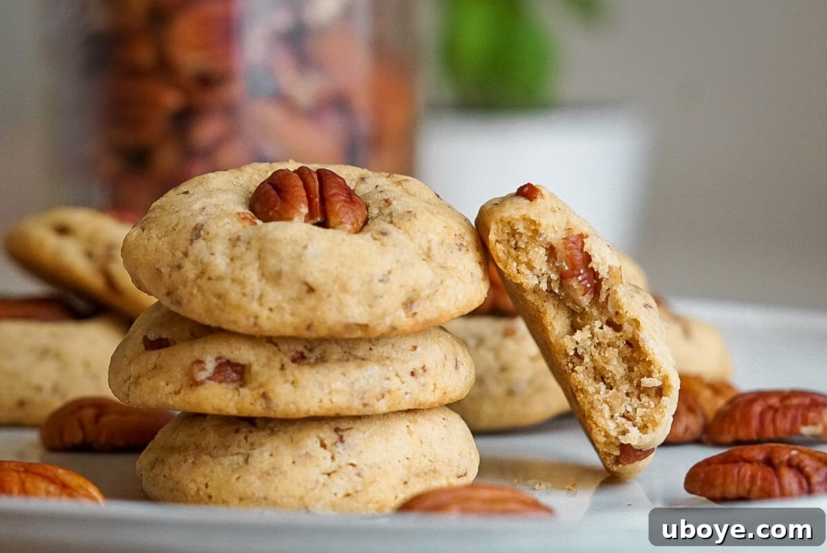 Close-up shot of freshly baked vegan butter pecan cookies adorned with whole pecans, ready to be enjoyed