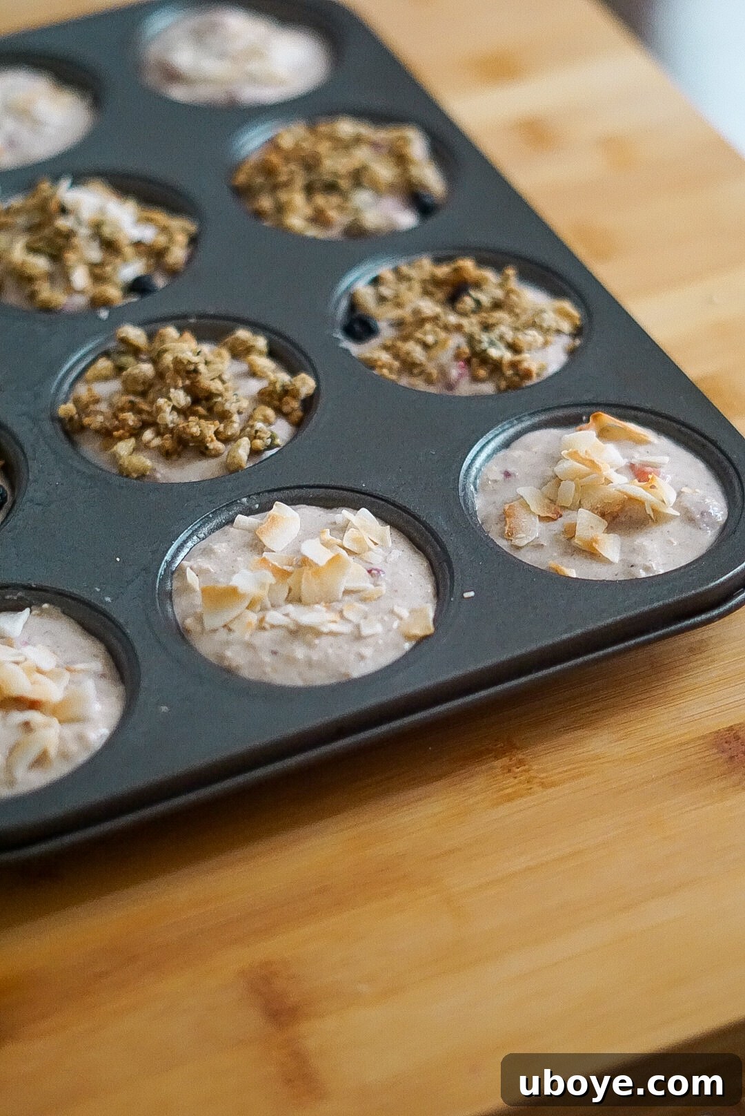 muffin batter meticulously spooned into a 12-hole muffin tin, ready for the oven