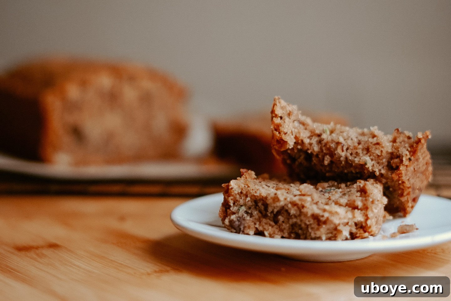 A close-up shot of the perfectly textured interior of vegan zucchini bread, showing a moist crumb and visible pecan pieces, ready to be sliced.