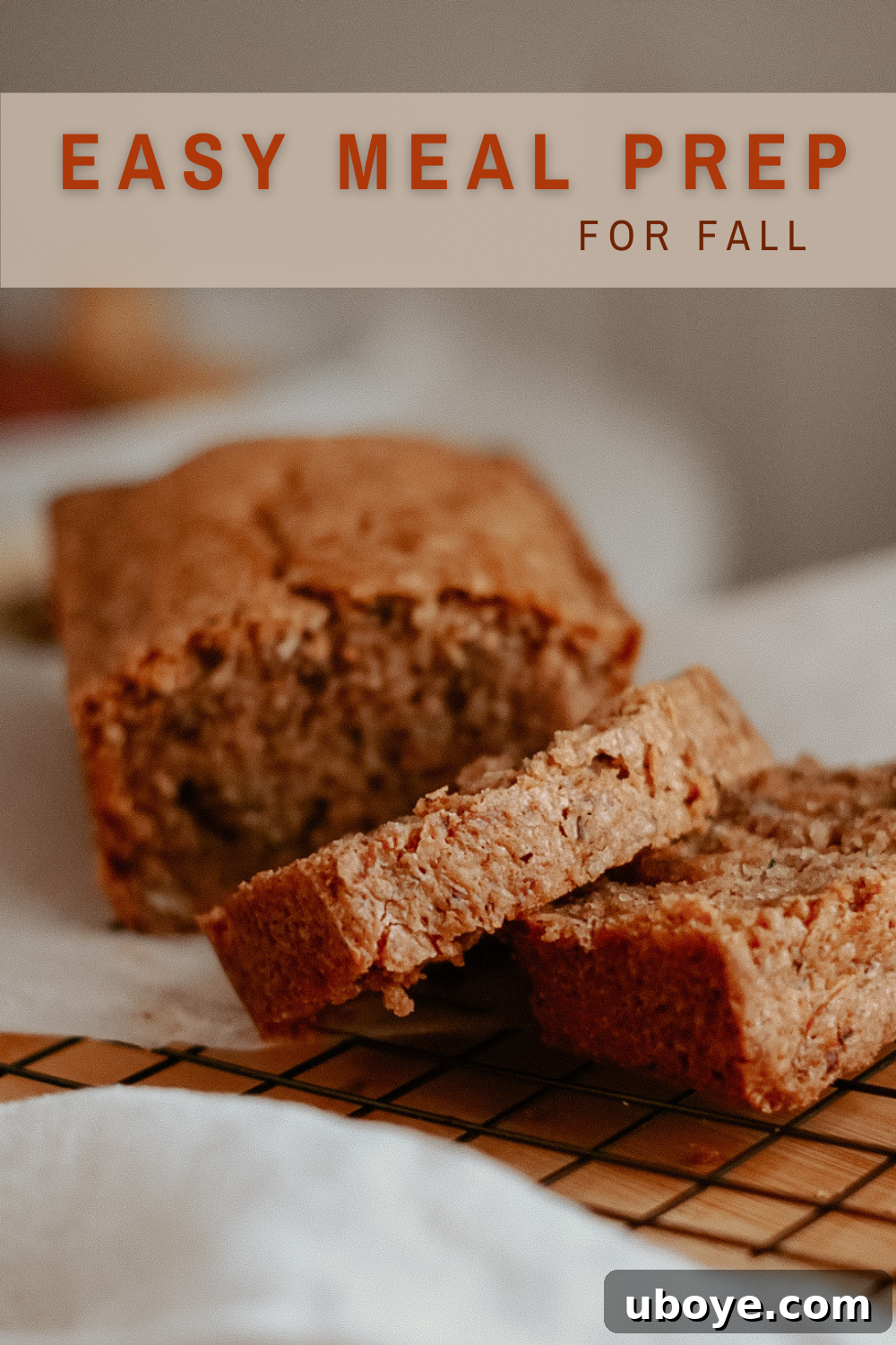 A vibrant, styled flat lay featuring a warm slice of vegan zucchini bread, a comforting cup of coffee, and autumnal decorations like leaves and cinnamon sticks.