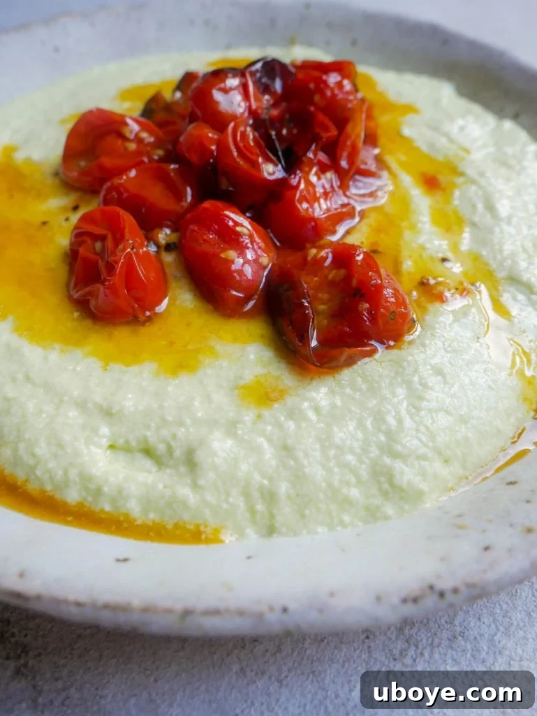 Close-up of whipped avocado and cream cheese spread in a bowl with a spoon