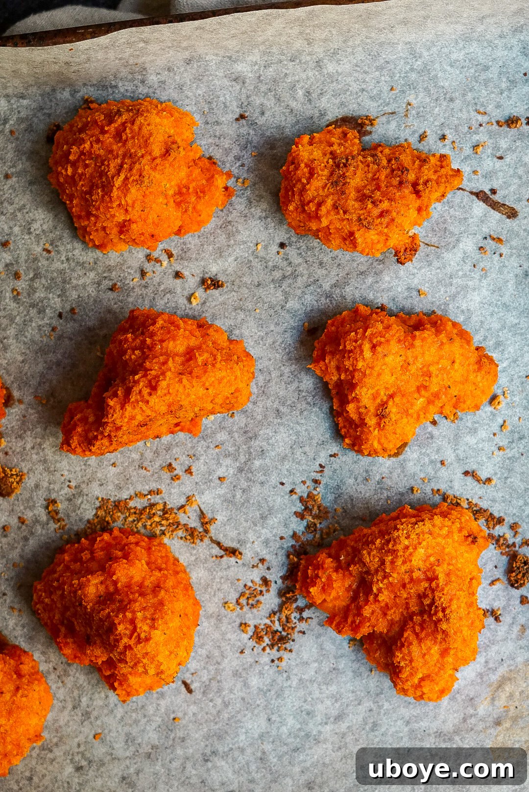 Baked vegan buffalo cauliflower wings on a baking sheet