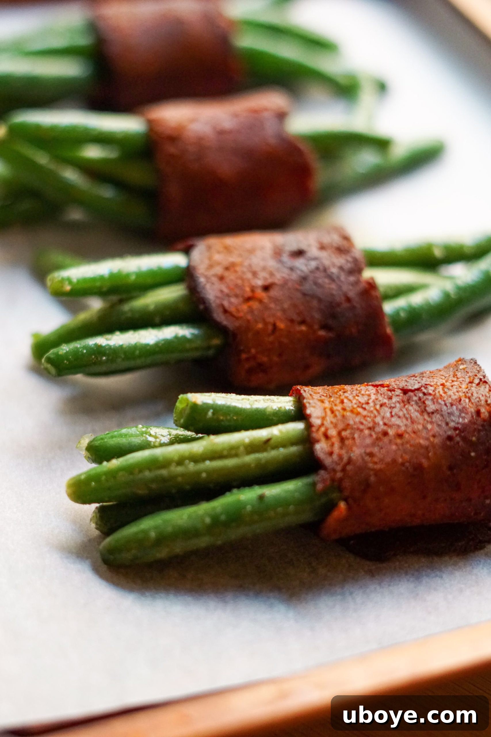 Savory Vegan Green Bean Bacon Bites 2 Crispy vegan bacon wrapped around tender green bean bundles, ready to be served