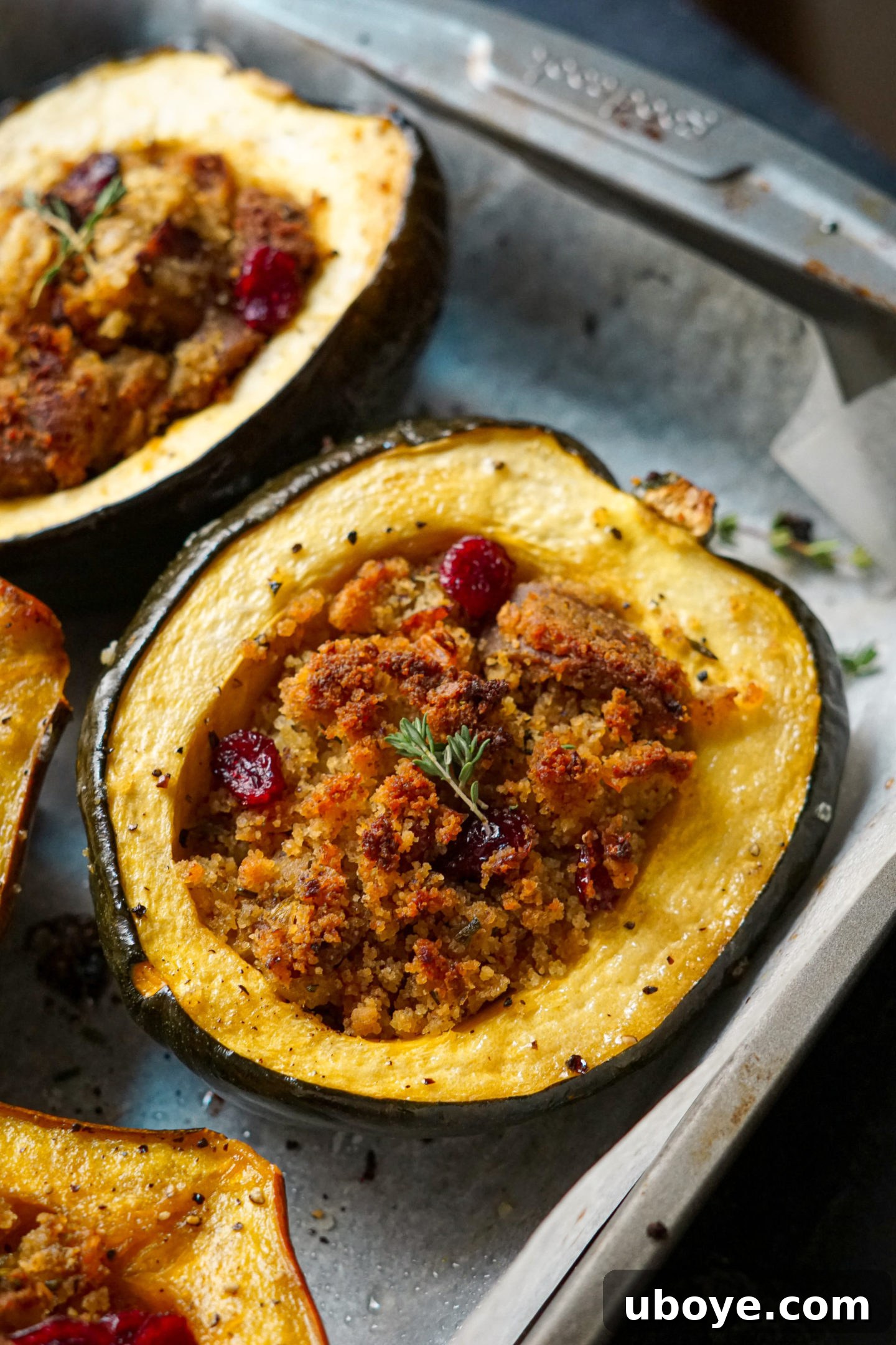 Raw acorn squash halves with seeds removed, ready for seasoning and stuffing preparation.