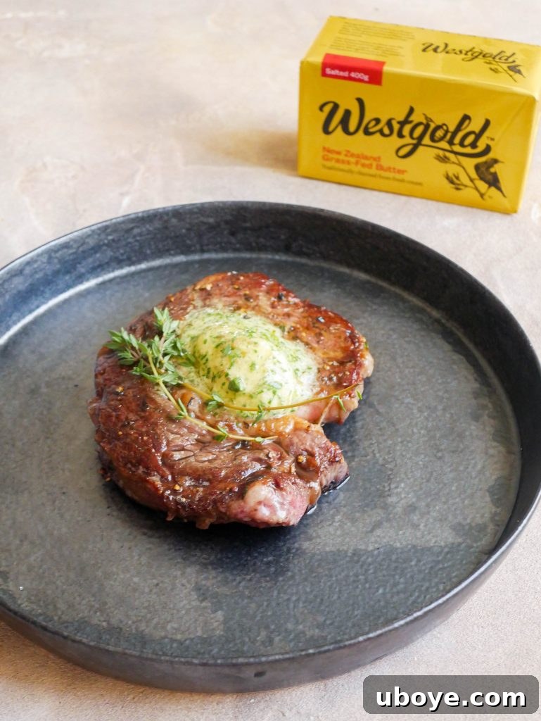 A beautifully plated steak with garlic confit herb butter, resting beside a fresh green salad, meticulously prepared and ready to be served.