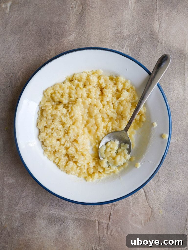 Pastina in a white bowl with a spoon, ready to be enjoyed.