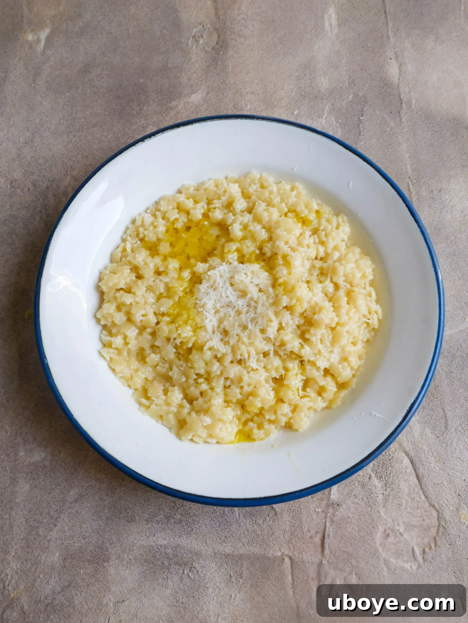 A finished bowl of creamy pastina, drizzled with olive oil and sprinkled with extra parmesan.